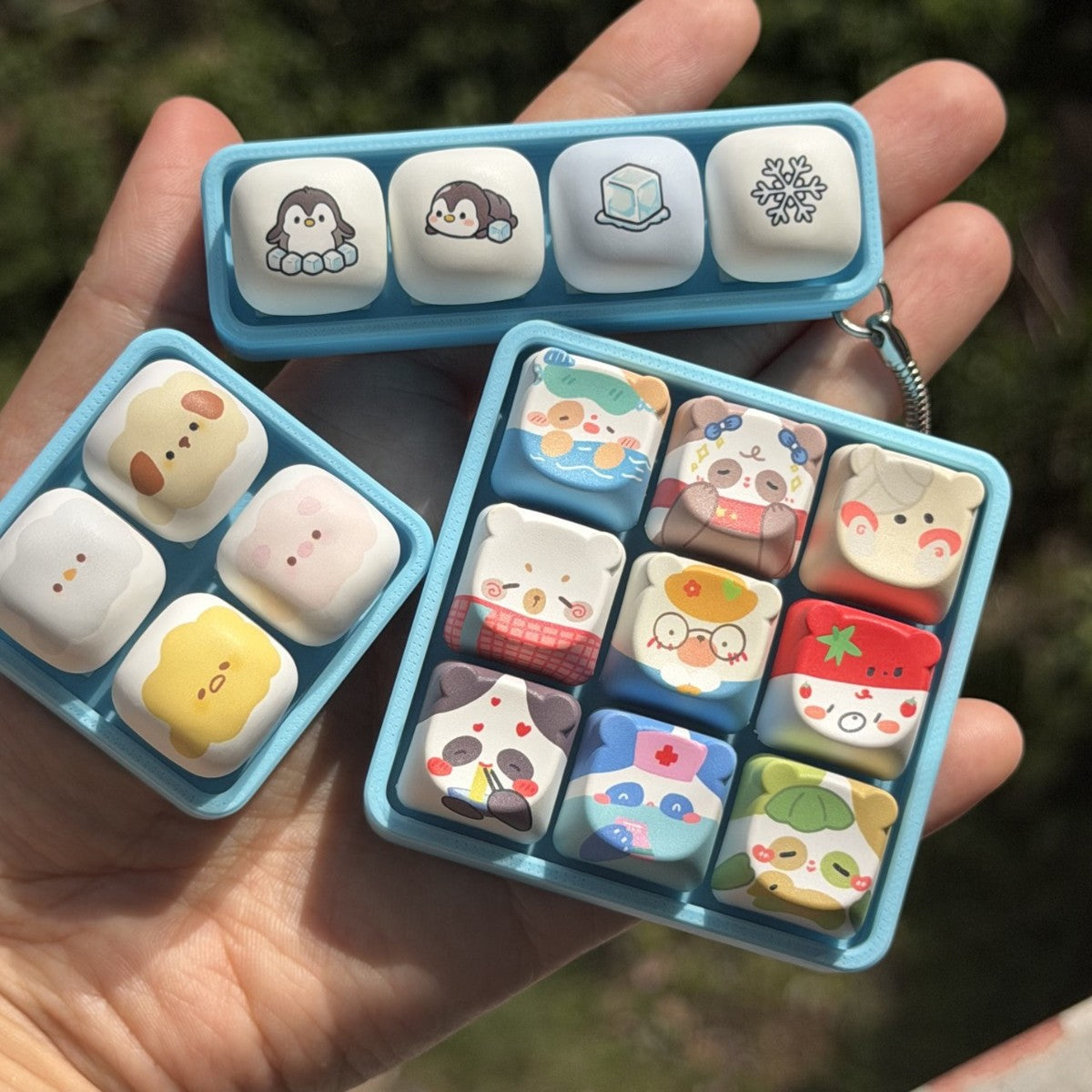 Cartoon animal keycap clicker keychains in blue frames: 9-key bears and 4-key penguins
