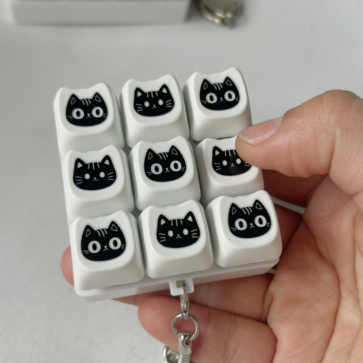 Black Cat Face keycap clicker keychain, 9-Key Black Cat held in hand