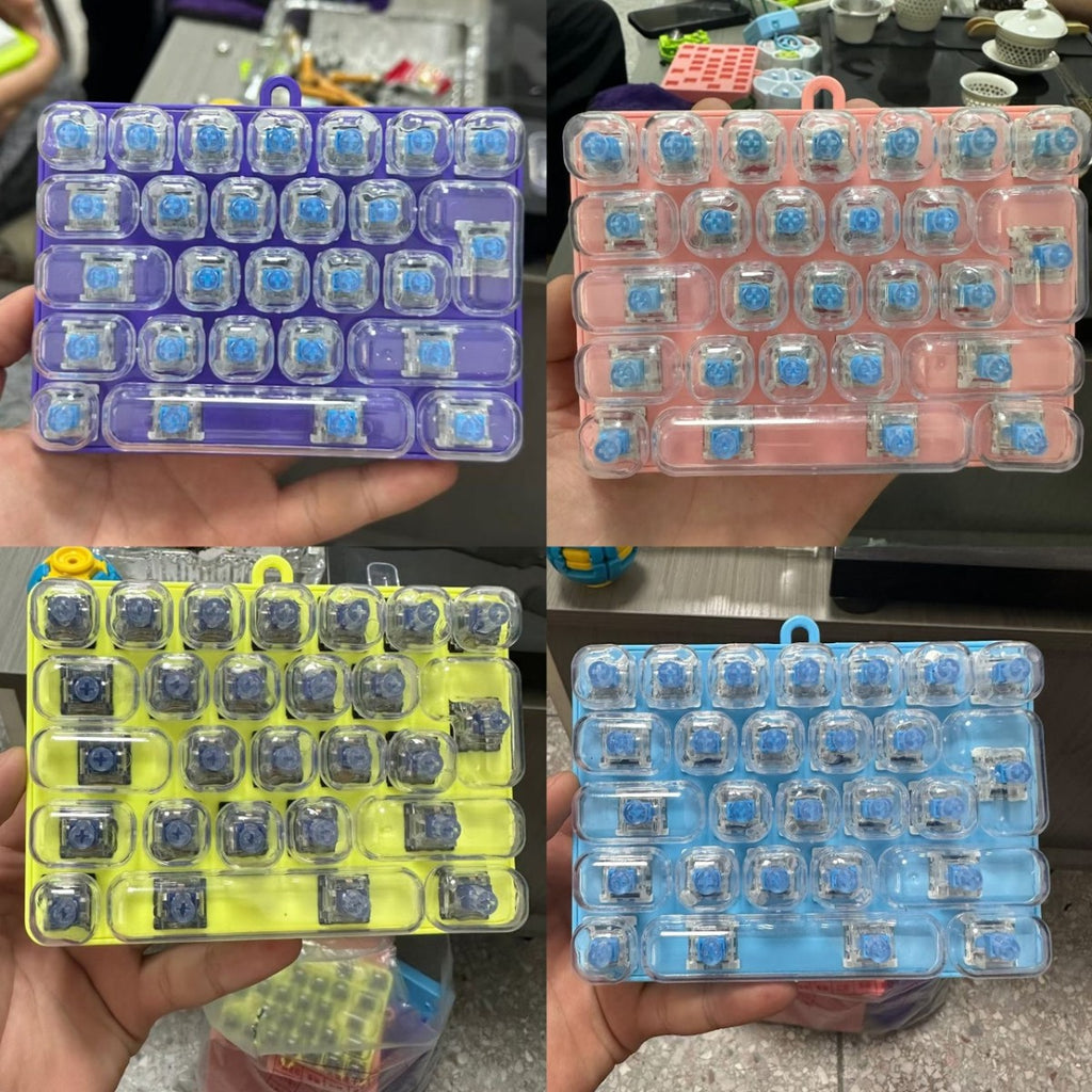 Four transparent 26-key mini keyboard clickers in purple, pink, yellow and blue frames