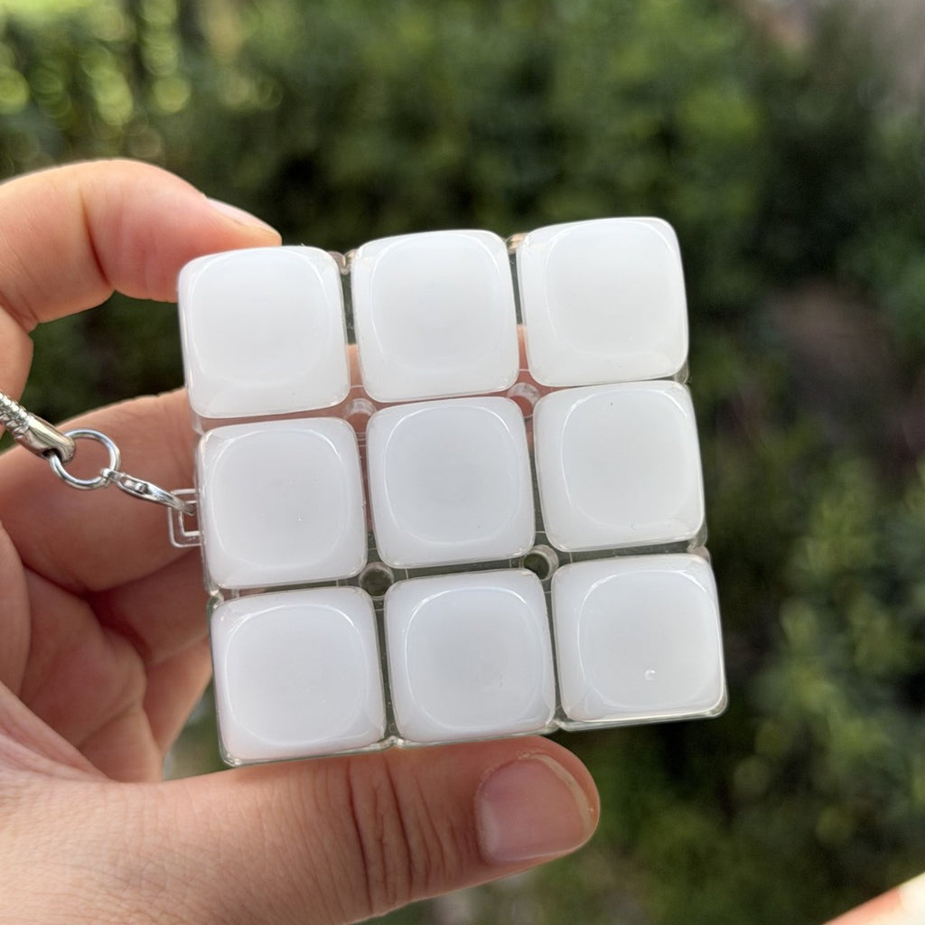 Frosted white 9-key keycap clicker keychain held in a hand