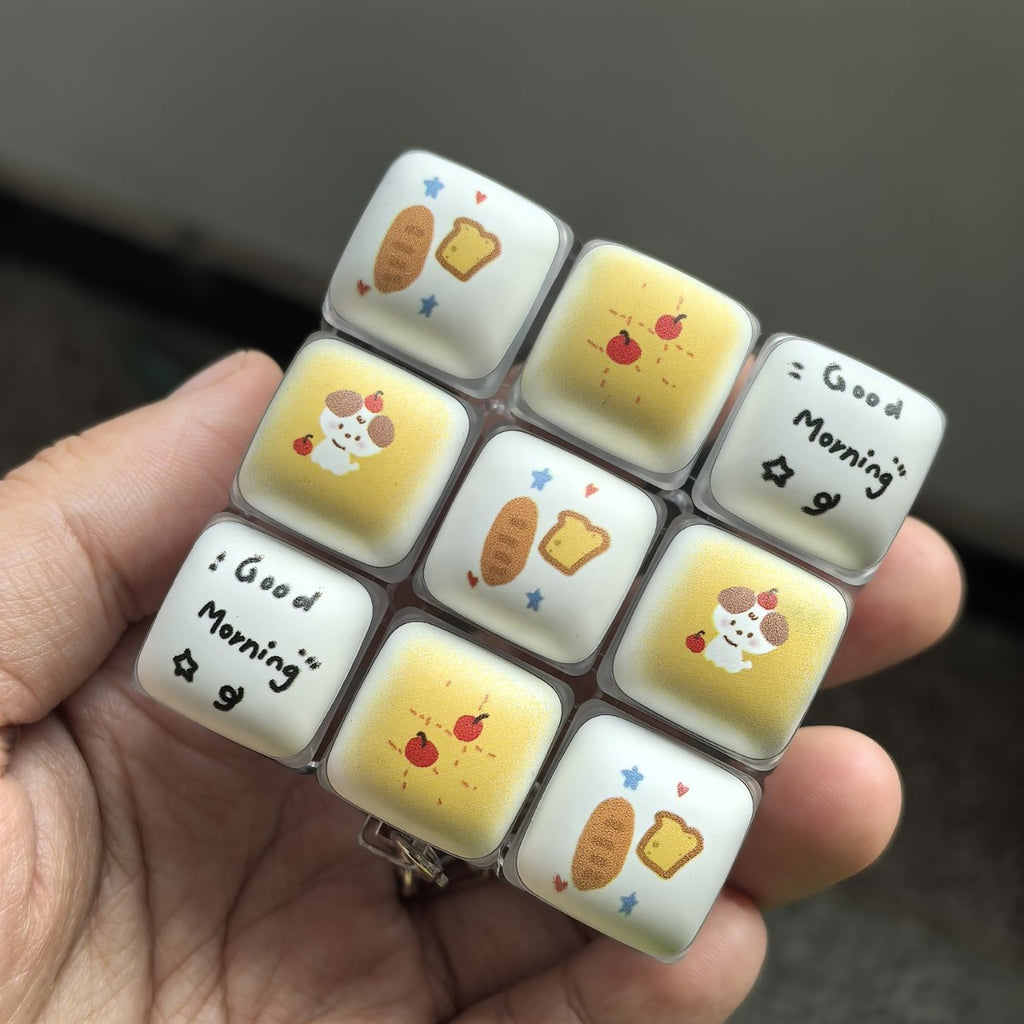 Good Morning bread 9-key keycap clicker held in a hand