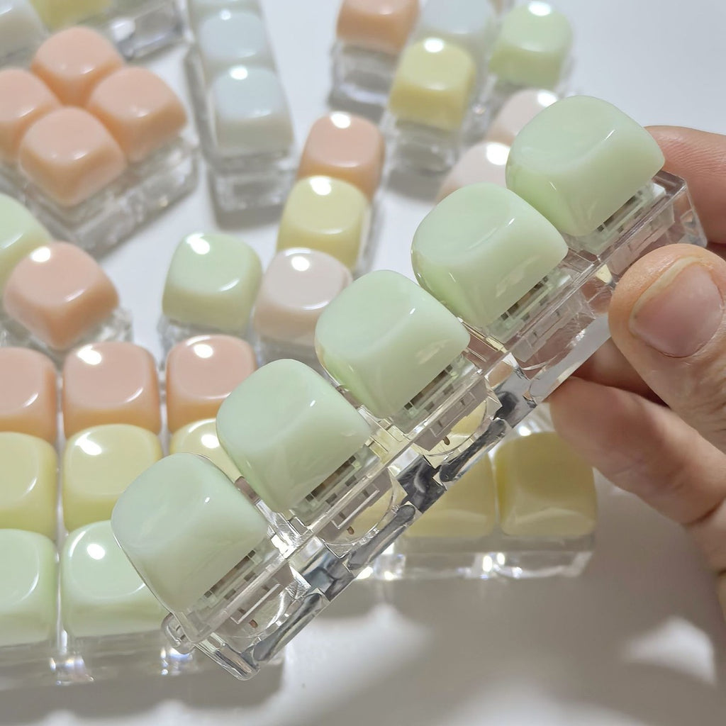 Hand holding rounded gummy keycap clicker keychains