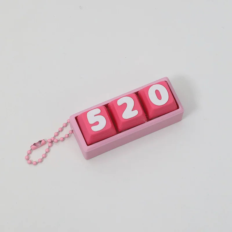 Pink 520 keycap clicker keychain with ball chain on a light grey background