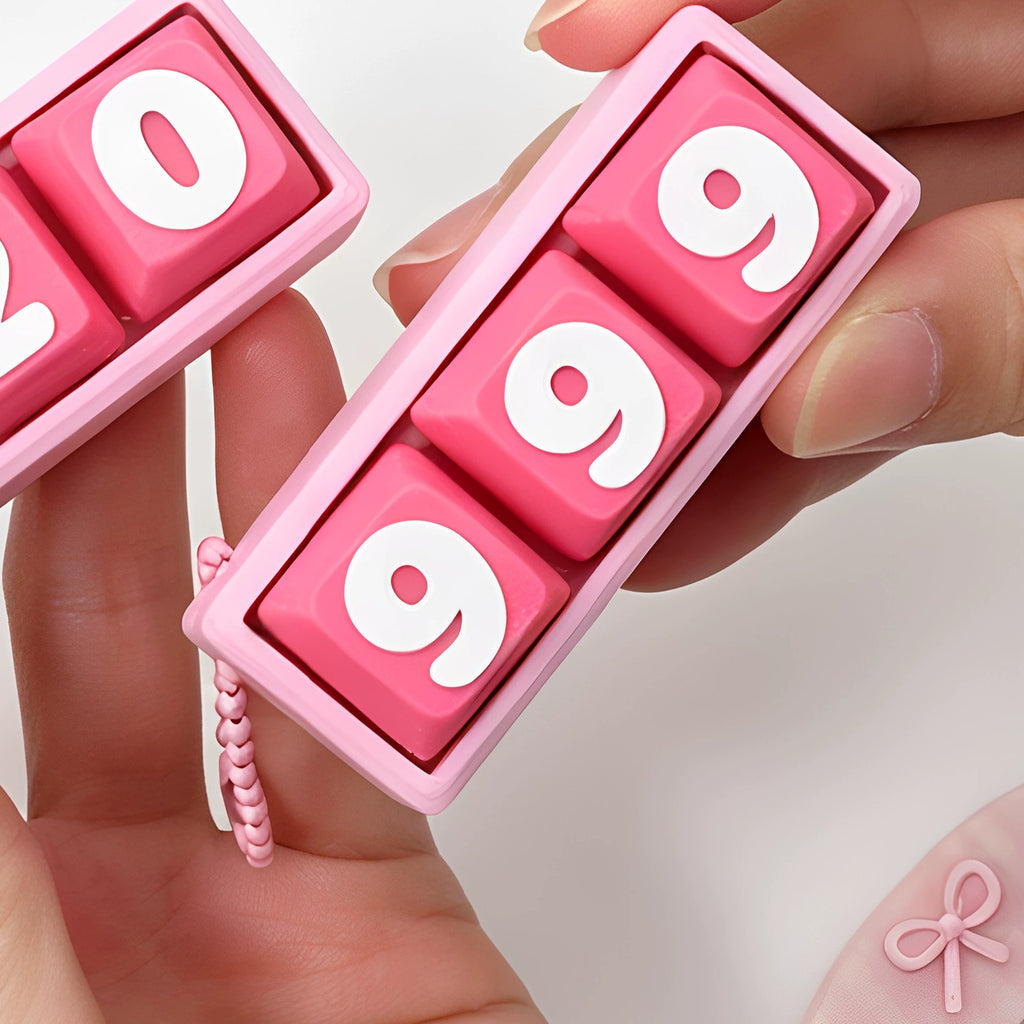 Hand holding the pink 999 keycap clicker keychain