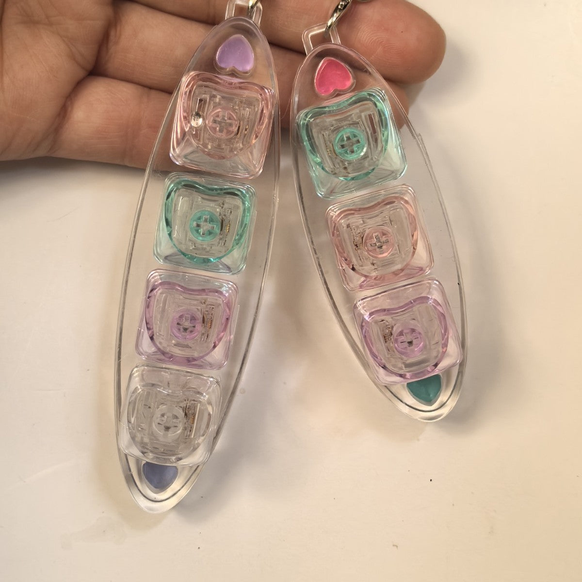 Hand holding leaf-shaped 3-key keycap clicker keychains