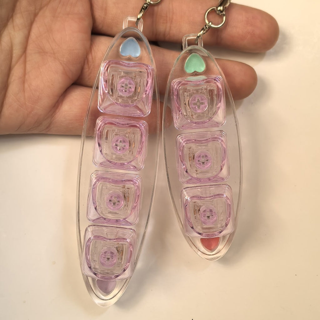 Pink and mint leaf-shaped keycap clicker keychains held in a hand