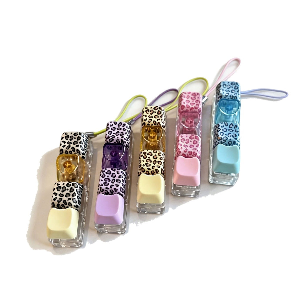 Leopard-print keycap clicker keychains in pink, blue, purple and yellow