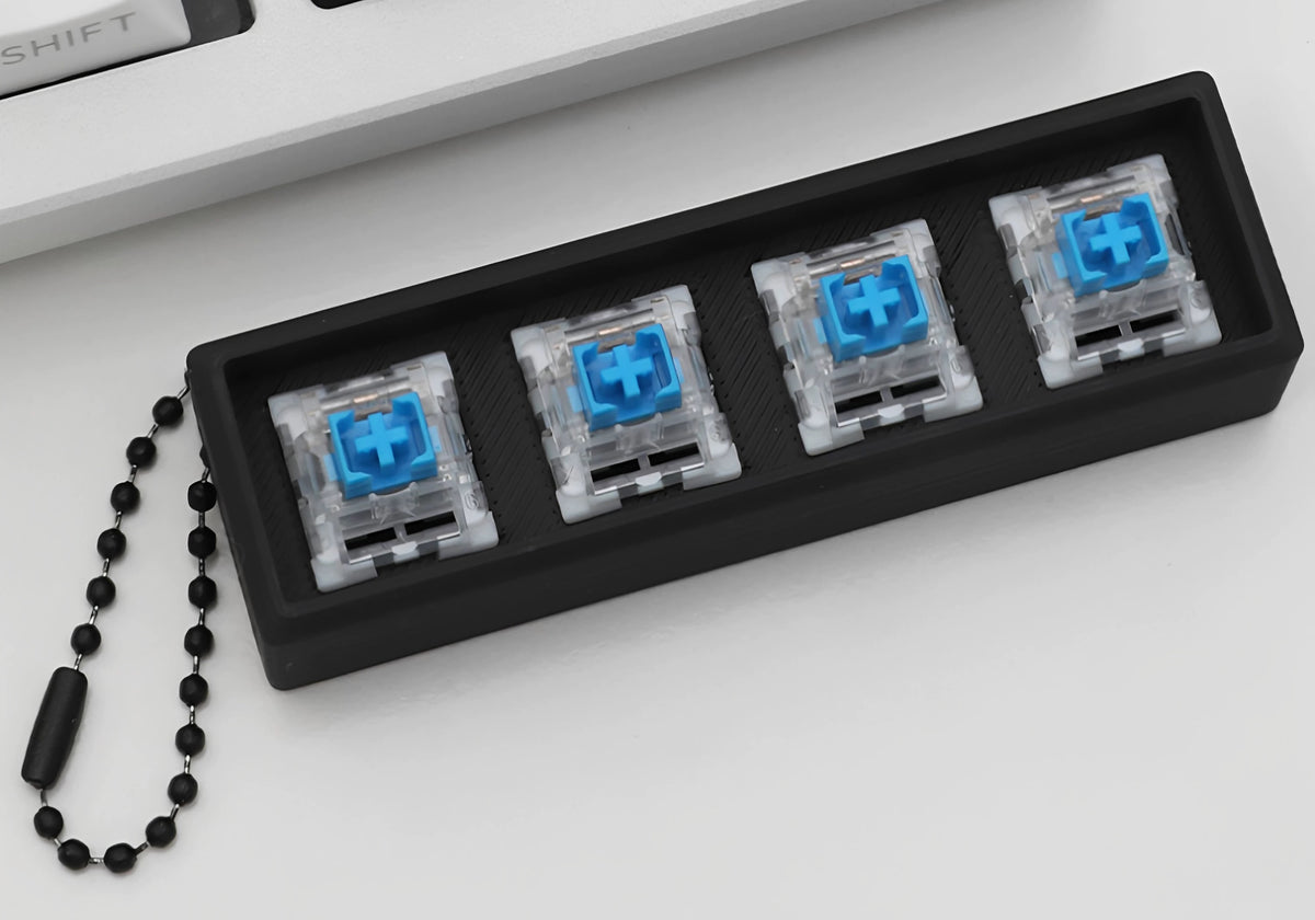 Magic cat clicker keychain case with keycaps removed showing four blue switches