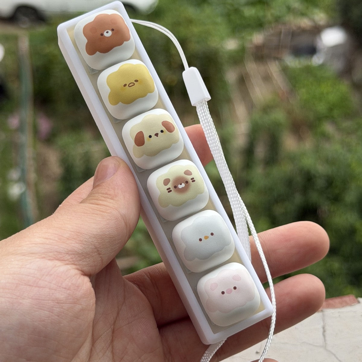Marshmallow animal 6-key keycap clicker held at an angle