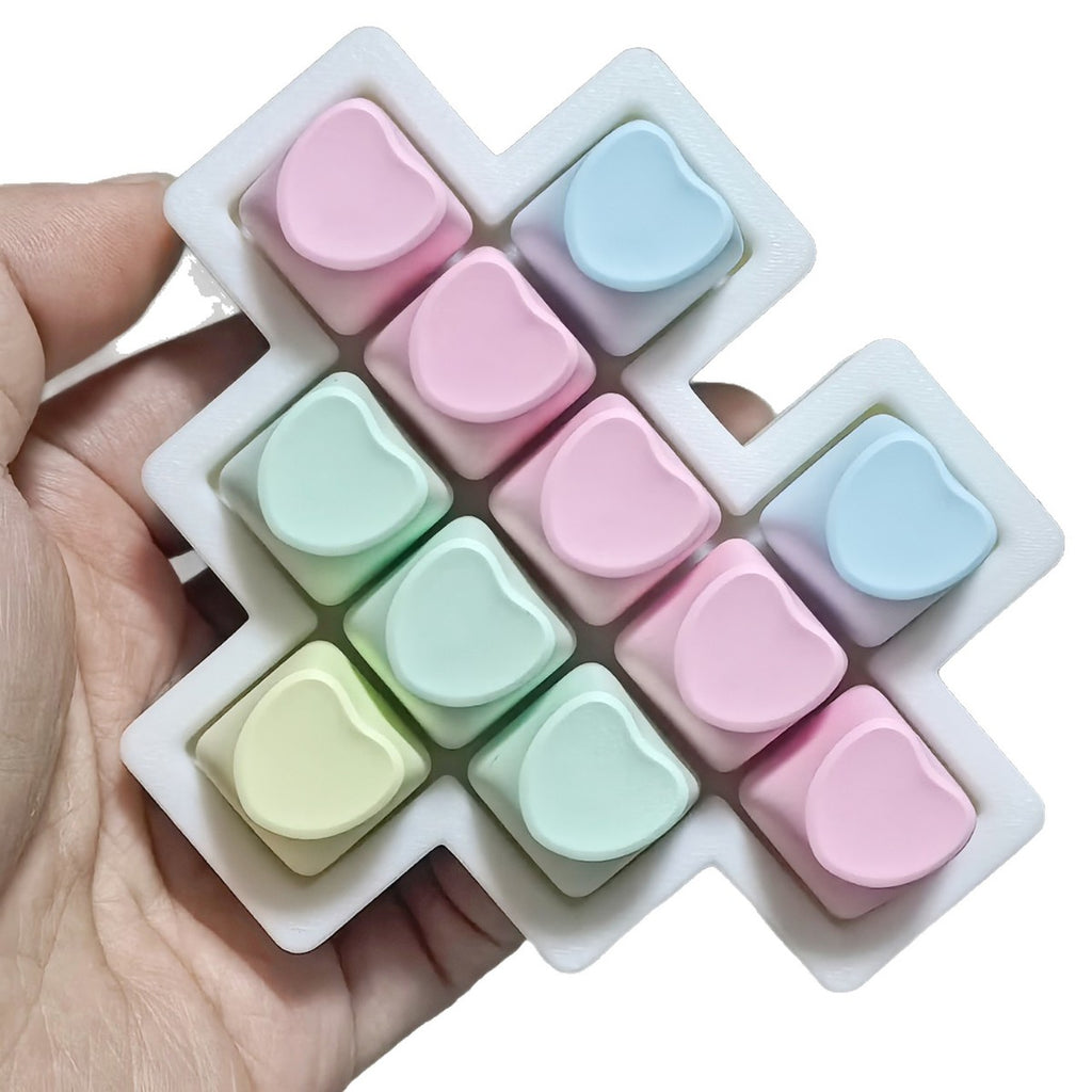 Pastel heart 11-key keycap clicker held in a hand