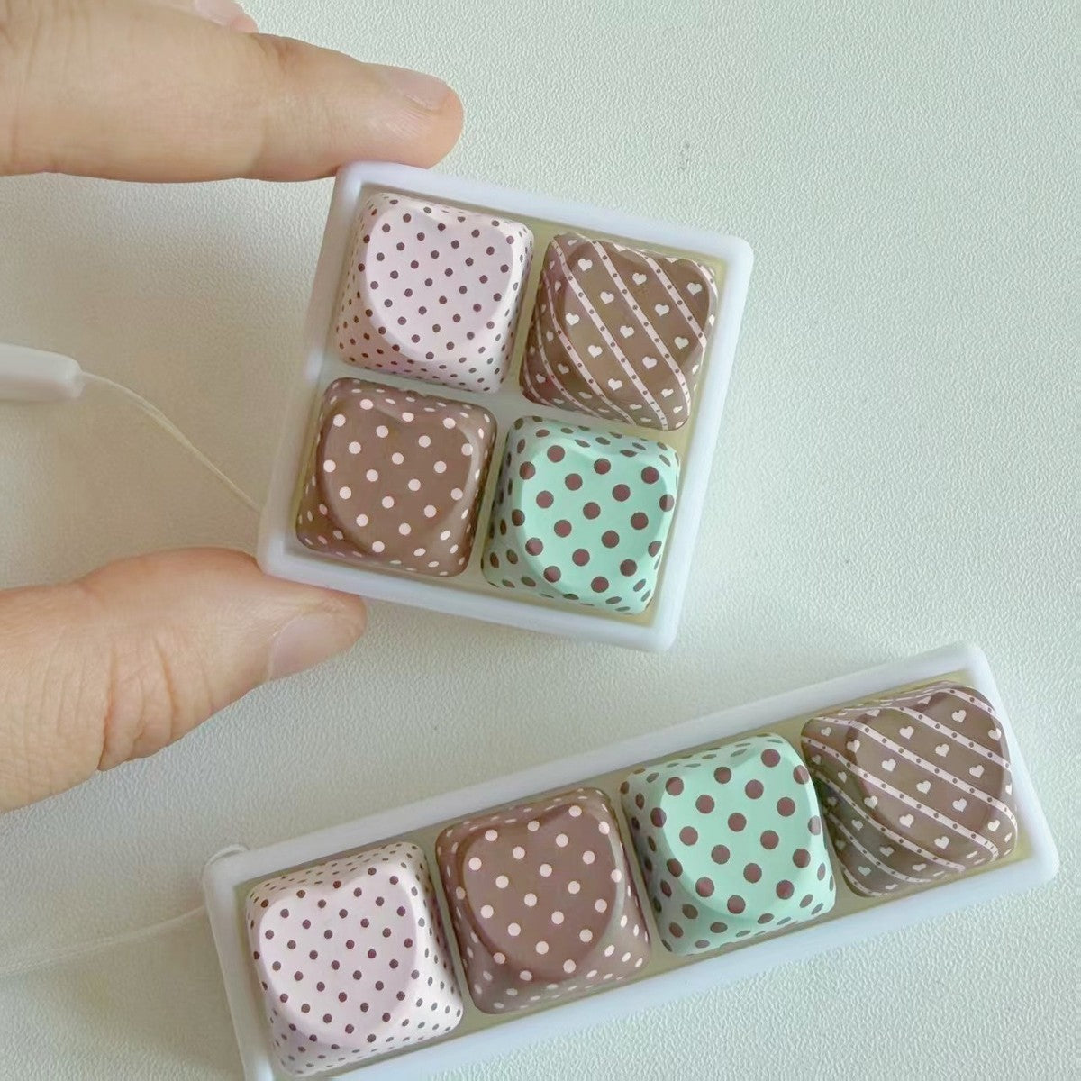 Hand holding polka-dot keycap clicker keychains