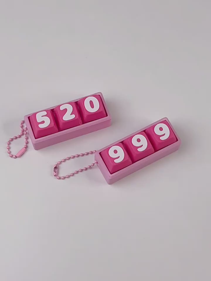 Video of pink 999 and 520 keycap clicker keychains being pressed