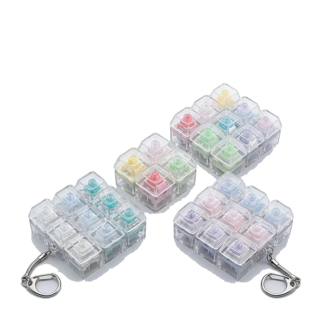 Quiet-switch keycap clicker keychains in clear housings with pastel keycaps
