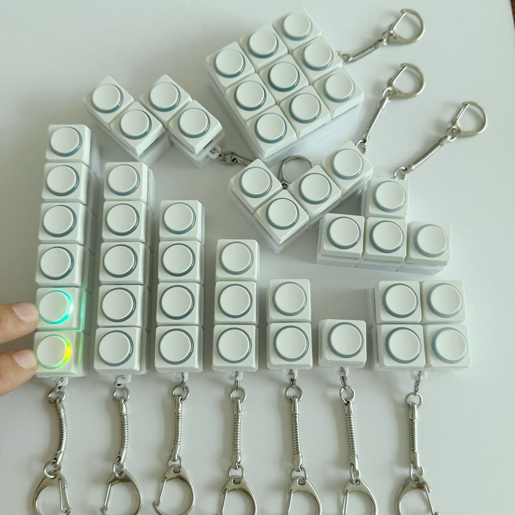 White round-button clicker keychains in 1 to 9-key layouts