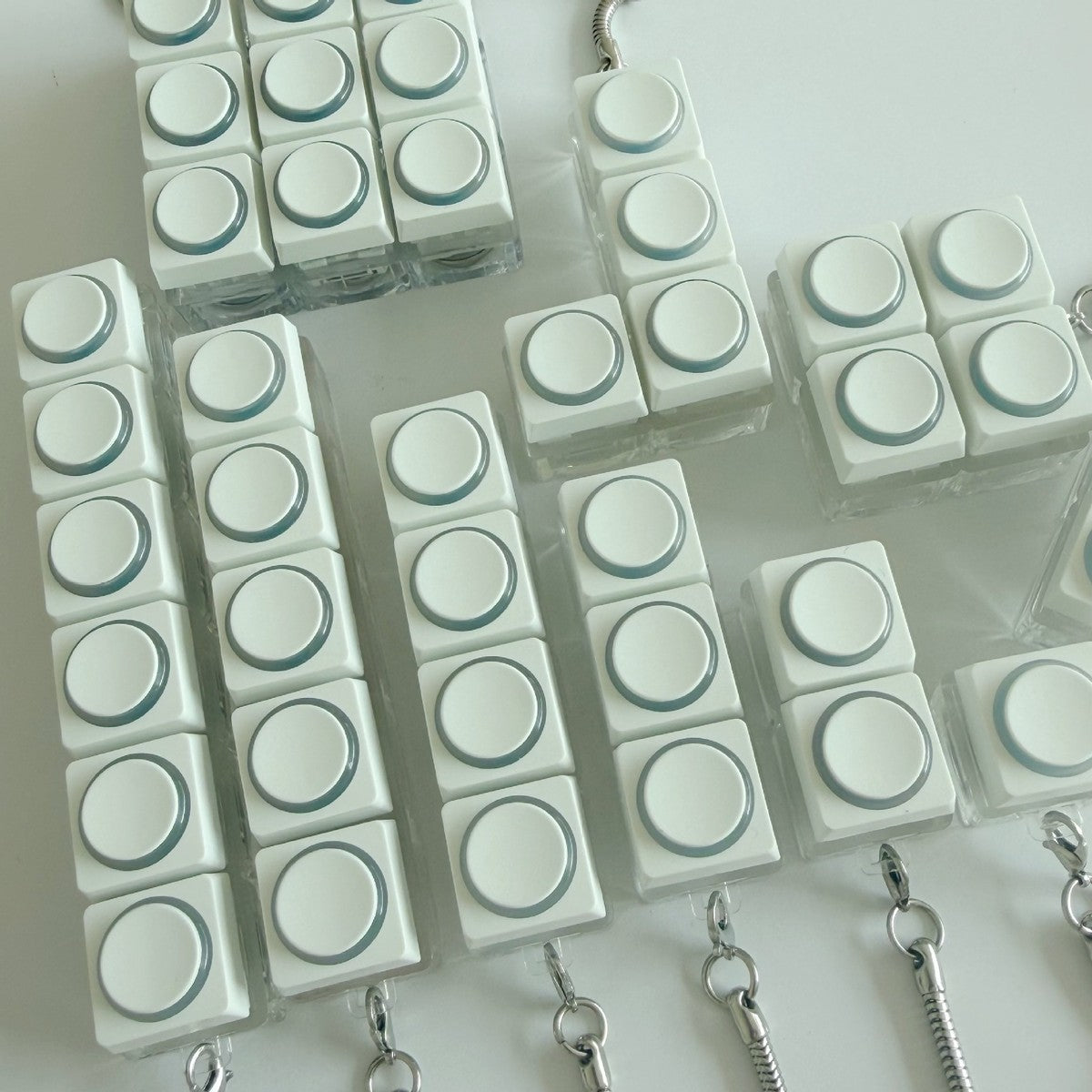 White round-button clicker keychains in several layouts