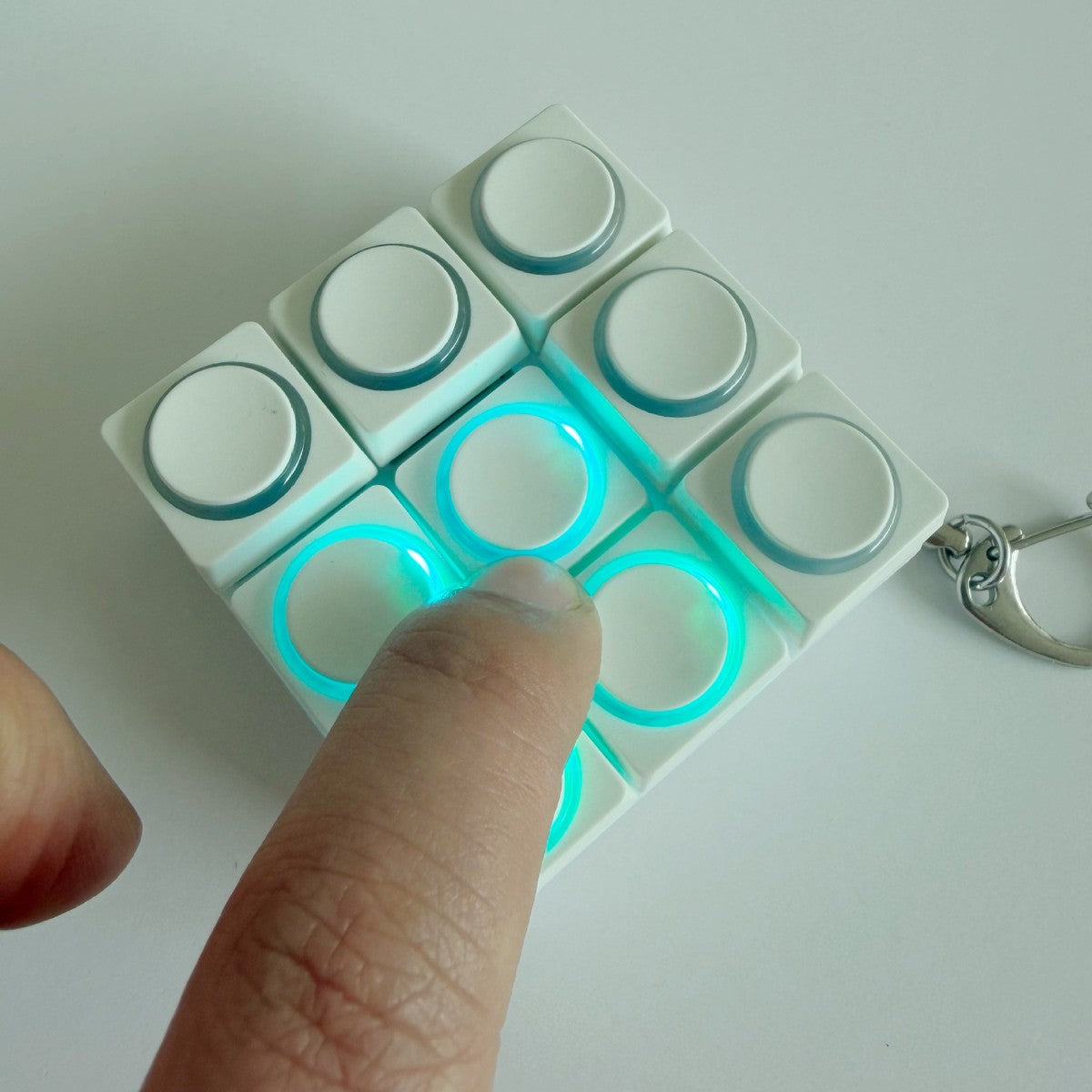 4-grid white round-button clicker keychain with a glowing ring
