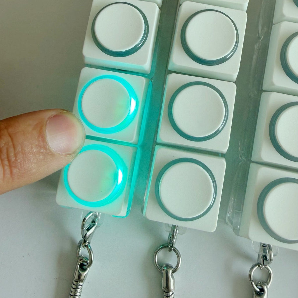 Close-up of white round-button clicker keychains